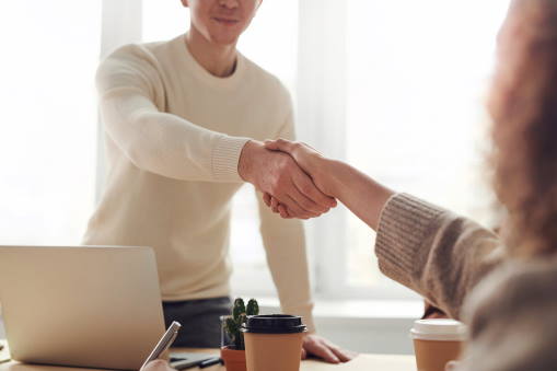 Two people shaking hands over a deal