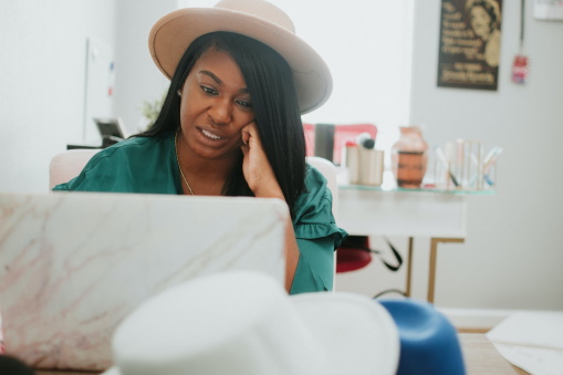 Image of a lady struggling on a laptop